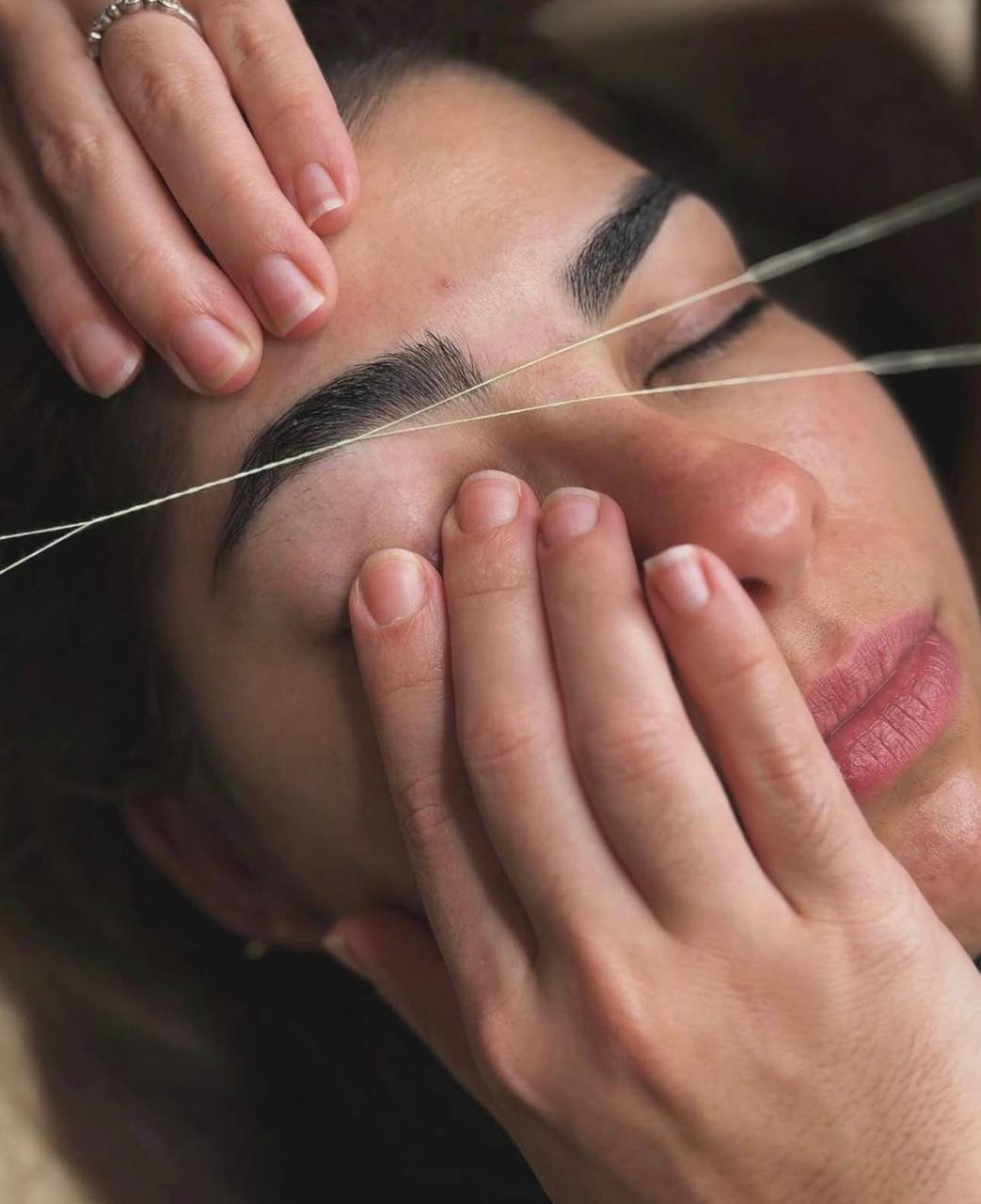 Eyebrow threading precision service — close-up of threading technique at American Laser Plus studio