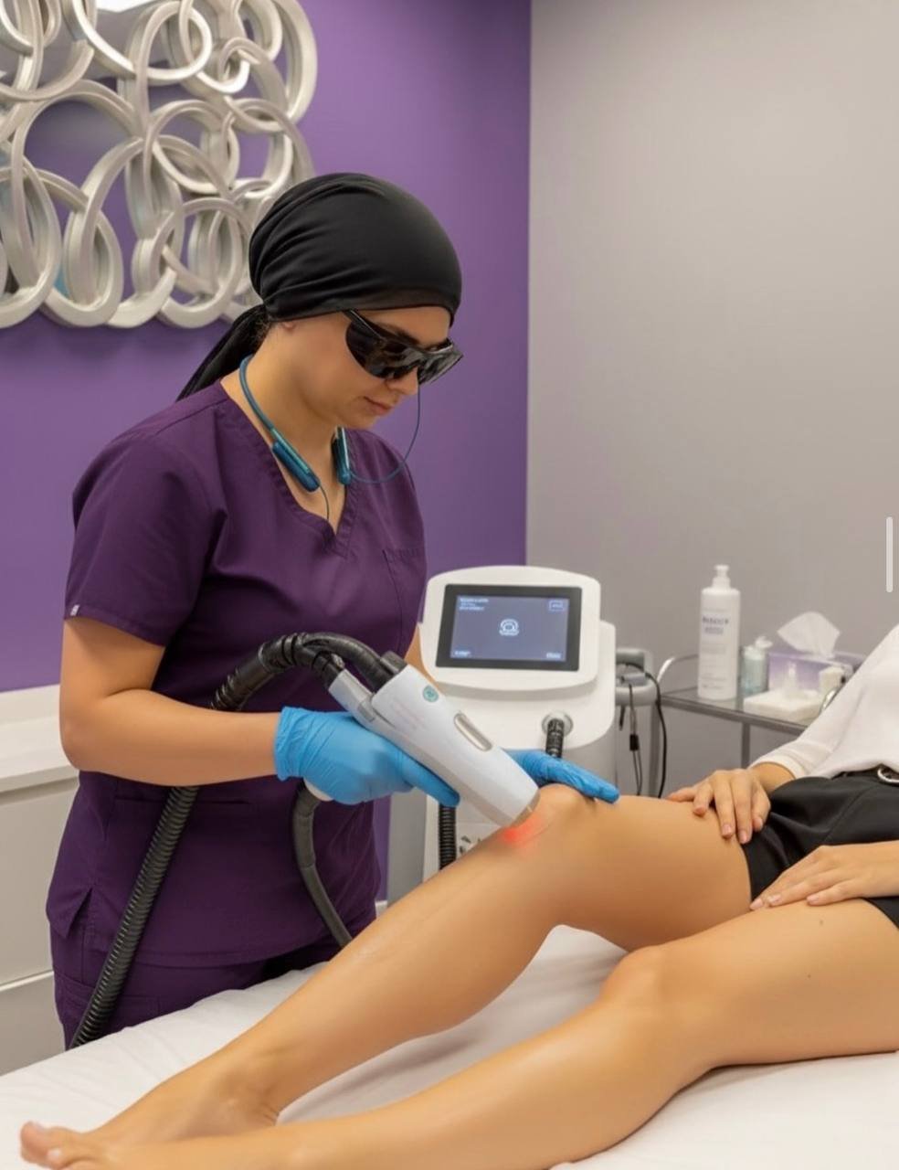 Certified laser technician performing laser hair removal on legs using professional equipment at American Laser Plus